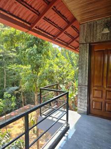 a porch of a house with a wooden door at CENTAURUS Coorg HOMESTAY in Madikeri