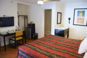 a hotel room with a bed and a desk and a television at Musicland Hotel in Palm Springs +52 photos