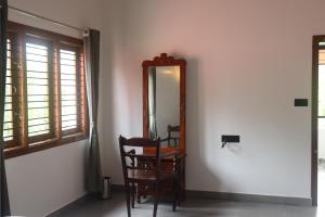 a mirror in a room with a chair and a table at Taniva Dani by CoffeeBeanVilla in Sakleshpur +41 photos