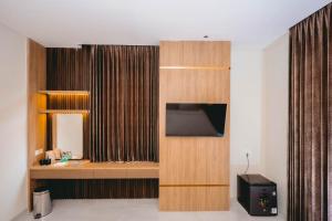 a hotel room with a tv and a room with at Front One Hotel Mesir Surabaya in Surabaya