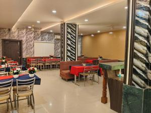 a restaurant with tables and chairs in a room at Hotel Surya in Datia