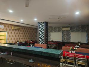 a room with tables and chairs and a stage at Hotel Surya in Datia