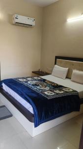 a bedroom with a large bed with a blue blanket at Hotel Surya in Datia +17 photos