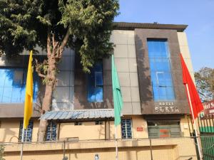 three flags in front of a building at Hotel Surya in Datia