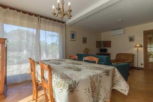 a dining room with a table and a room with a couch at Le mas clair in Pins-Justaret