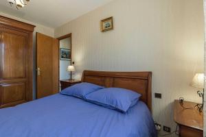 a bedroom with a blue bed with two blue pillows at Le mas clair in Pins-Justaret