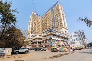 a tall building with cars parked in front of it at Sunhaven Studio I Work & Leisure Stays I Near Expo Mart in Greater Noida