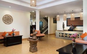 a lobby of a hotel with a woman in the background at Indochine Sanctuary Boutique in Siem Reap +104 photos