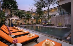 a hotel with a swimming pool and tables with hats on them at Indochine Sanctuary Boutique in Siem Reap