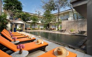 a row of benches next to a pool at a hotel at Indochine Sanctuary Boutique in Siem Reap