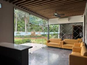 a living room with two couches and a large window at Windsor House in Secunderabad