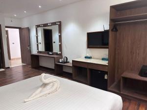 a hotel room with a bed and a mirror at Windsor House in Secunderabad