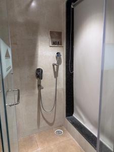 a shower with a hose in a shower stall at Windsor House in Secunderabad +54 photos