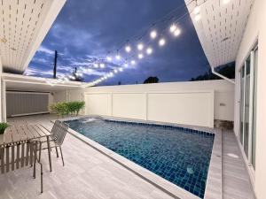 a swimming pool with lights on a house at Buddy pool villa in Nong Prue