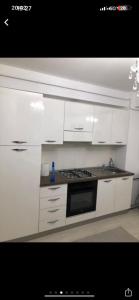 a kitchen with white cabinets and a stove top oven at Expo Copou in Iaşi