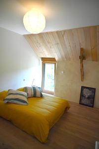 a large yellow bed in a room with a window at Louzou Les Chambres Aux Loups in Iffendic