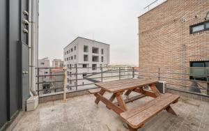 a wooden picnic table on the balcony of a building at Orago Stay Hotel in Suwon