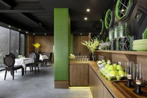 Holly Wood Motel في Pitou: غرفة طعام مع طاولة وعمود أخضر