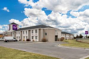 a large white building with a purple sign on it at Sleep Inn Billings in Billings