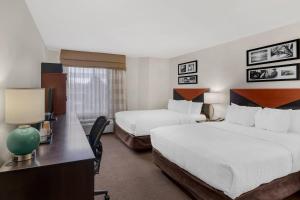a hotel room with two beds and a desk at Sleep Inn Billings in Billings +28 photos