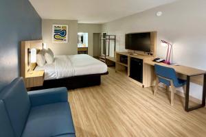 a hotel room with a bed and a desk and a television at Park Inn by Radisson, Weldon - Roanoke Rapids in Weldon