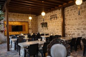 a dining room with tables and chairs and a tv at Osmanli Marco Pasha Hotel in Tarsus +40 photos