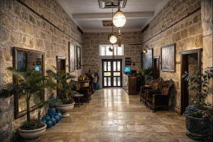 a lobby with plants and chairs in a building at Osmanli Marco Pasha Hotel in Tarsus