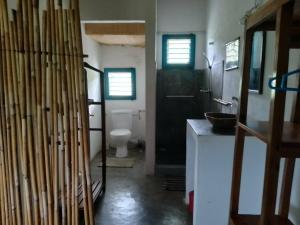 a bathroom with a toilet and a black door at Corto Novo Maison d'hôtes-Camping in Nosy Be +76 photos
