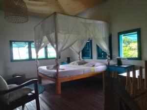 a bedroom with a bed with a canopy at Corto Novo Maison d'hôtes-Camping in Nosy Be