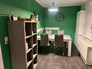 a dining room with green walls and a table and chairs at Ferienhaus Isaro in Ludwigsburg