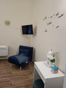 a living room with a blue chair and a white table at Dolce Dormire in Vigevano