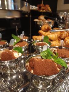 ein Buffet mit mehreren Tabletts voller Speisen auf einem Tisch in der Unterkunft Hotel Le Corderie in Triest + 40 Fotos