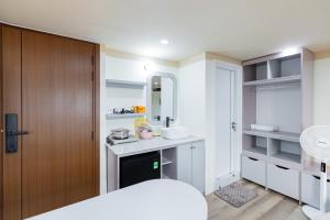 a white bathroom with a sink and a mirror at Hội Home in Ho Chi Minh City