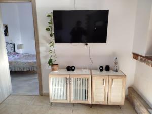 a living room with a tv on a wall at Spiti Lou in Nótos