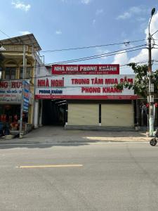 a building with signs on the side of a street at Phong Khánh Hostel in Than Uyên