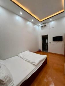 a bedroom with a bed and a flat screen tv at Phong Khánh Hostel in Than Uyên