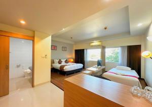a hotel room with a bedroom and a bed at Akelada Hotel in Nang Rong +123 photos