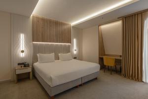 a bedroom with a white bed and a desk at Apart Hotel Istaravshan in Tashkent