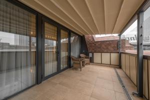 an empty balcony with glass doors and a chair at Apart Hotel Istaravshan in Tashkent