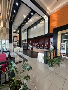 a lobby with a restaurant with tables and plants at Akelada Hotel in Nang Rong