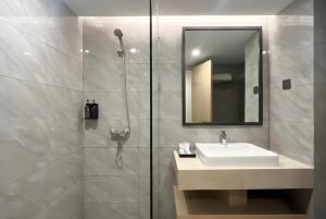 a bathroom with a sink and a shower with a mirror at MAXONE Batam in Nagoya +17 photos