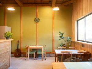 a room with a table and chairs and a guitar at Vegestay Nonaka in Tanabe