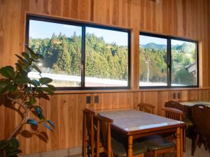 a dining room with a table and two windows at Vegestay Nonaka in Tanabe