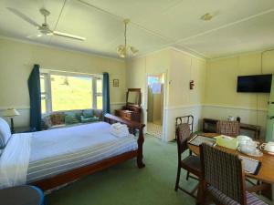 a bedroom with a bed and a desk and a desk at Fernbrook Lodge in Dorrigo