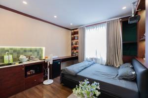a bedroom with a bed and a desk and a window at Hội Home in Ho Chi Minh City