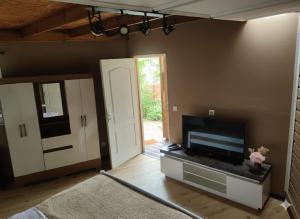 a living room with a flat screen tv next to a door at Le Lys des Makes in Saint-Louis