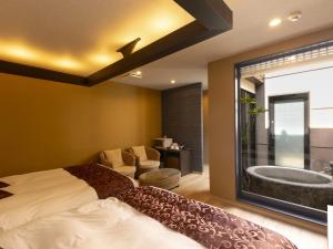 ein Schlafzimmer mit Bett und Badewanne in der Unterkunft 大分温泉 Business Resort Sourin in Ōita