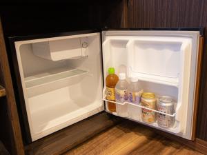 ein offener Kühlschrank mit Milch und Getränken darin in der Unterkunft 大分温泉 Business Resort Sourin in Ōita