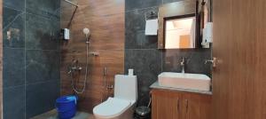 a bathroom with a sink and a toilet and a mirror at Rivero Resort in Dirang Dzong