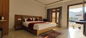 a bedroom with a bed and a large window at Rivero Resort in Dirang Dzong
